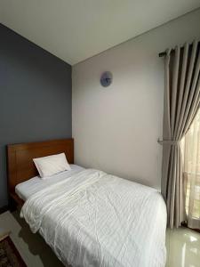 a bedroom with a white bed and a window at Villa Qfa Syariah in Lembang