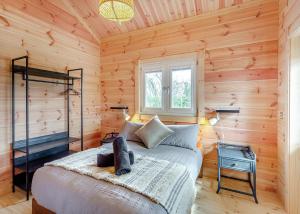 a bedroom with a bed in a wooden cabin at Holly Tree Lodges in York