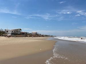 een strand met mensen die op het zand en de oceaan lopen bij LA SERENA in Aguas Dulces