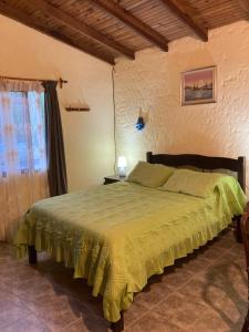 een slaapkamer met een bed met een groene sprei bij LA SERENA in Aguas Dulces