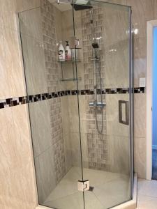 a shower with a glass door in a bathroom at Guest Suite - Cosy place in the Wattle Downs in Auckland