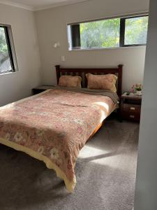 een slaapkamer met een groot bed en een groot raam bij Guest Suite - Cosy place in the Wattle Downs in Auckland