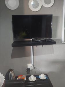 a flat screen tv hanging on a wall at Nsuku Bed and Breakfast in Thulamahashi