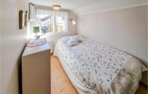 een kleine slaapkamer met een bed en een raam bij Stunning Home In Hovenset With 3 Bedrooms in Hovenäset
