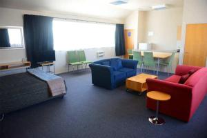 a room with a bed and chairs and a table at Victoria Court Motor Lodge in Wellington