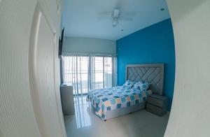 - une chambre bleue avec un lit et une fenêtre dans l'établissement Depa el señor, à Ciudad Guzmán