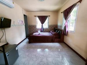 1 dormitorio con 1 cama y 2 ventanas en Win Gray Homestay Resort en Pathiu