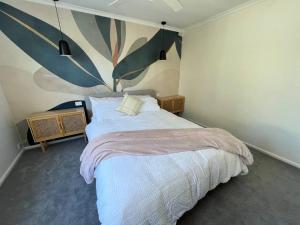 um quarto com uma cama e um quadro na parede em Cosy Eildon Getaway em Eildon