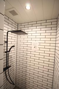 a bathroom with a shower with white tiles at Roots inawashiro Lake Area in Sekiwaki