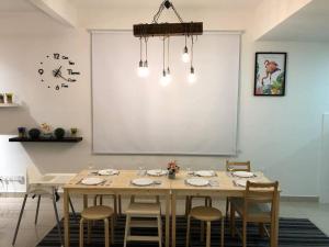 a dining room with a wooden table and chairs at Desaru Fun House For Family-Kids-AirCastle-BBQ-KTV in Bandar Penawar