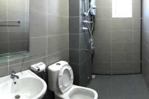 a bathroom with a toilet and a sink at Desaru Fun House For Family-Kids-AirCastle-BBQ-KTV in Bandar Penawar +12 photos