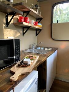 a kitchen with a counter with a sink and a microwave at On Bell Glamping in Belford