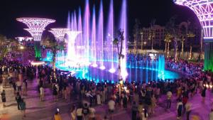 uma multidão de pessoas em frente a uma fonte à noite em Khách Sạn Hoàng Nam em Sam Son