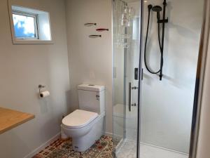 ein Badezimmer mit einem WC mit zwei an der Wand gezogenen Gesichtern in der Unterkunft Brighton Beach in Dunedin
