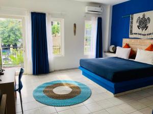 Dormitorio azul con cama y alfombra en Blue Ocean Hotel, en Labuan Bajo