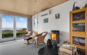 a living room with a fireplace and a view of the ocean at Cozy Home In Tranekr With Kitchen in Hou