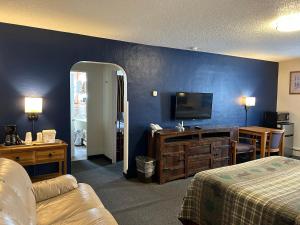 a hotel room with a bed and a flat screen tv at Great Western Colorado Lodge in Salida