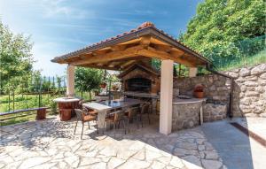 an outdoor kitchen with a wooden pergola at Pet Friendly Apartment In Icici With Wifi in Ičići