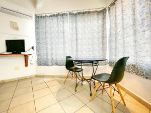 a room with a table and chairs and a television at Hotel Allende in La Paz