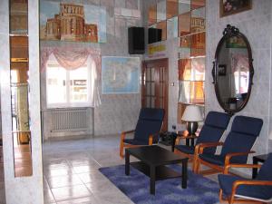 una sala de espera con sillas, mesa y espejo en Hotel Fray Juán Gil en Arévalo
