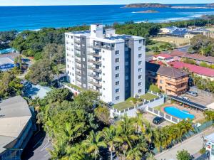 an aerial view of a building with the ocean in the background at Tradewinds Apartments in Coffs Harbour
