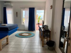 Schlafzimmer mit einem Bett, einem Schreibtisch und einem Fenster in der Unterkunft Blue Ocean Hotel in Labuan Bajo