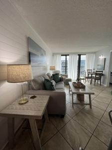 uma sala de estar com um sofá e uma mesa em Condo on the Beach- walk to restaurants, shops and activities. em Gulf Shores