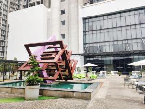 a sculpture in front of a building with tables and chairs at Grand Ion Delemen Premium Suites & Room by TOP HOME in Genting Highlands