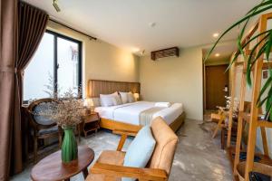 um quarto de hotel com uma cama e um sofá em Nam An Mama Villa Hoi An em Hoi An