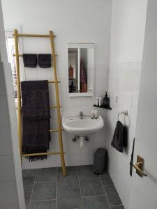 a white bathroom with a sink and a mirror at Cape Colonnades alleyway in Cape Woolamai