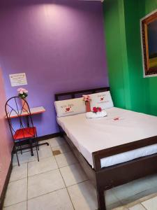 1 dormitorio pequeño con 1 cama y 1 silla en WJV INN CANDUMAN, en Mandaue