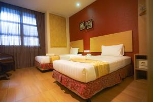 新山的住宿－GODORI HOTEL SDN BHD，酒店客房设有两张床和钢琴