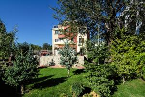 ein Haus inmitten eines Hofes mit Bäumen in der Unterkunft FANTASY APARTMENTS in Warna