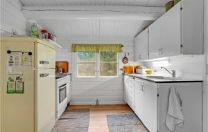 una cucina con mobili bianchi e un frigorifero bianco di 3 Bedroom Lovely Home In Rømø a Mølby