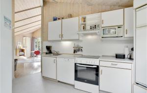 a white kitchen with white cabinets and appliances at Holiday Home Grærup Havvej Oksbøl Iv in Vejers Strand