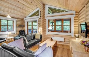 una sala de estar con paredes y muebles de madera y ventanas en 3 Bedroom Amazing Home In Fars en Hvalpsund