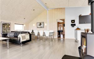 sala de estar con sofá negro y sillas blancas en Gorgeous Home In Bogense With Indoor Swimming Pool, en Bogense