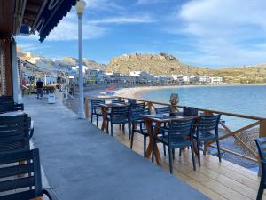 restauracja z krzesłami i stołami oraz plaża w obiekcie VILLA BLANCA w mieście Charaki