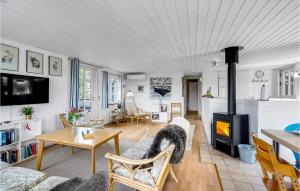 a living room with a table and a fireplace at Nice Home In Fan With Wifi in Fanø