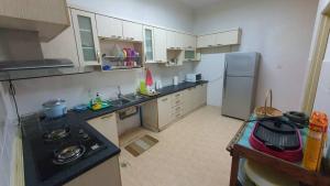 a kitchen with a stove and a refrigerator at Vision Homestay in Seremban