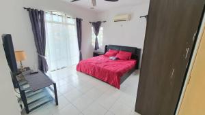 a bedroom with a red bed with a red blanket at Vision Homestay in Seremban