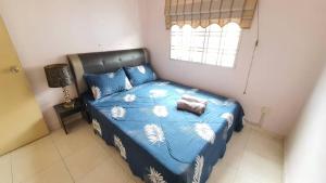 une chambre avec un lit avec une couette bleue et une fenêtre dans l'établissement Vision Homestay, à Seremban 1 autre photo
