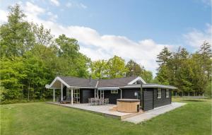 a black modular house with a deck in a yard at 3 Bedroom Nice Home In Hasle in Tofte