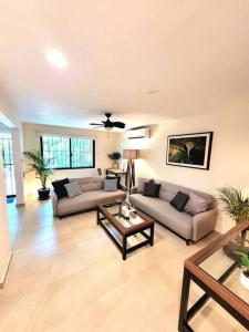 uma sala de estar com dois sofás e uma mesa em Departamento Céntrico y Moderno en Cancún. em Cancún