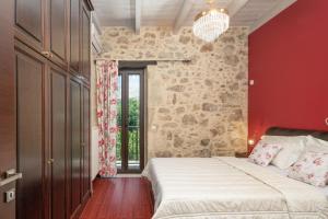 sypialnia z dużym łóżkiem i czerwoną ścianą w obiekcie Villa Lambraki w mieście Síva