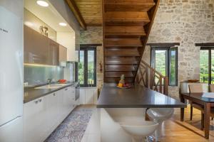 a kitchen with white cabinets and a wooden ceiling at Villa Lambraki in Síva