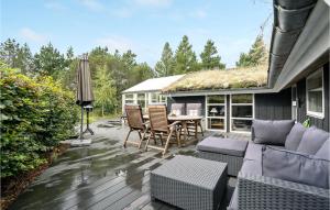un patio con sofá, sillas y mesa en Liroke, en Blåvand
