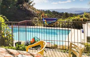 einen Pool mit zwei Stühlen neben einem Zaun in der Unterkunft Gorgeous Home In Mercuer With Outdoor Swimming Pool in Mercuer
