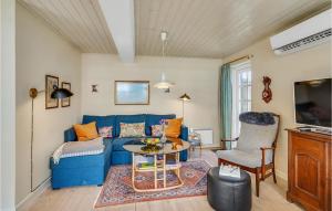 a living room with a blue couch and a table at Awesome Home In Skrup Fyn With House A Panoramic View in Skårupøre