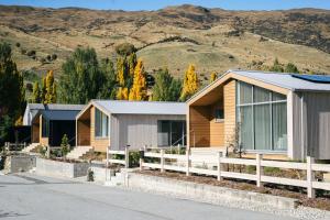 uma fila de casas modulares em frente a uma montanha em Abodo Alpine Eco Villa (Spa) em Cardrona